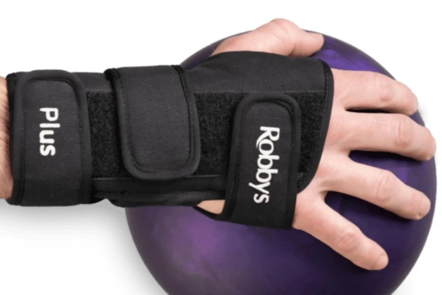 Hand wearing wrist support holding a bowling ball