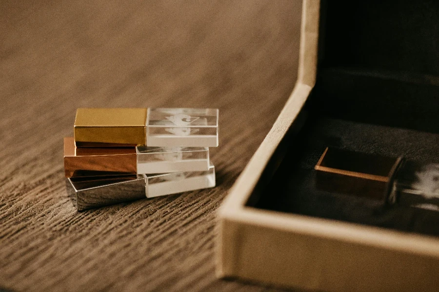 Heap of modern USB flash drives against wooden box on rough surface on blurred background by Jonathan Borba