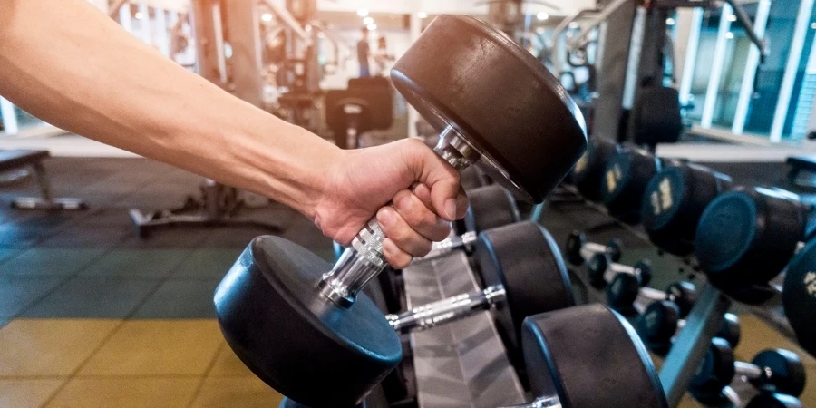 Human Hand holding dumbbell in gym