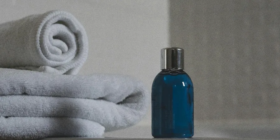 Blue Glass Bottle Beside White Towel