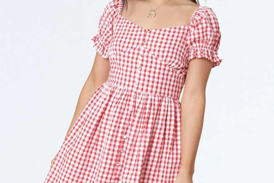 Lady leaning sideways in a gingham milkmaid dress