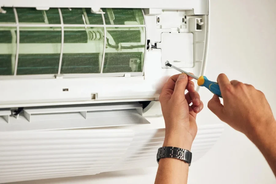 Maintenance, air conditioner and hands of man with screwdriver for problem solving on machine