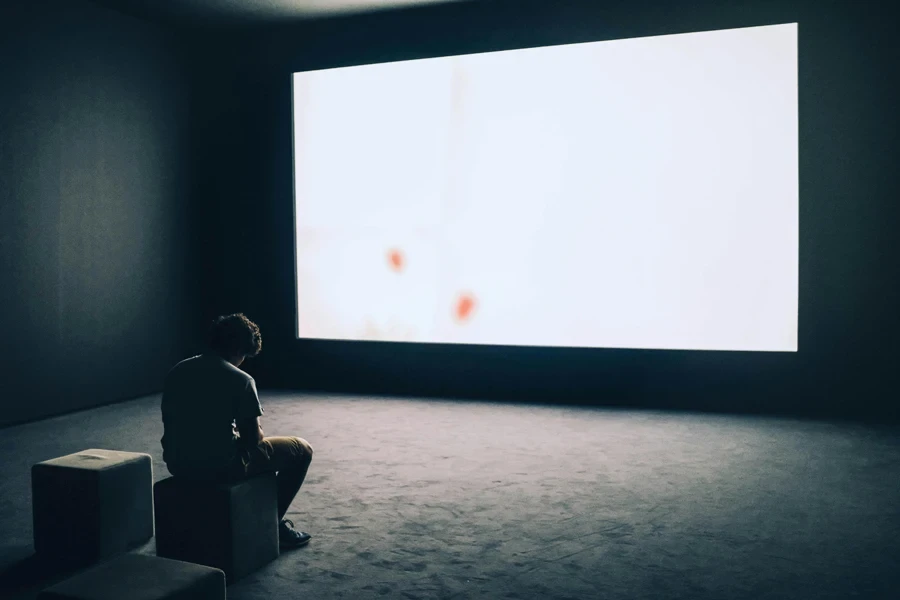 Man Sitting in Front of Turned-on Screen