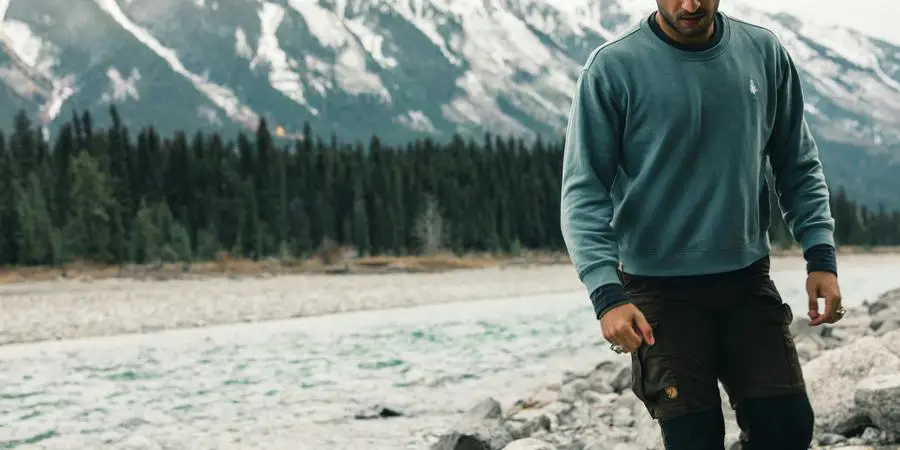 Man Walking near a Rocky River by Ali Kazal