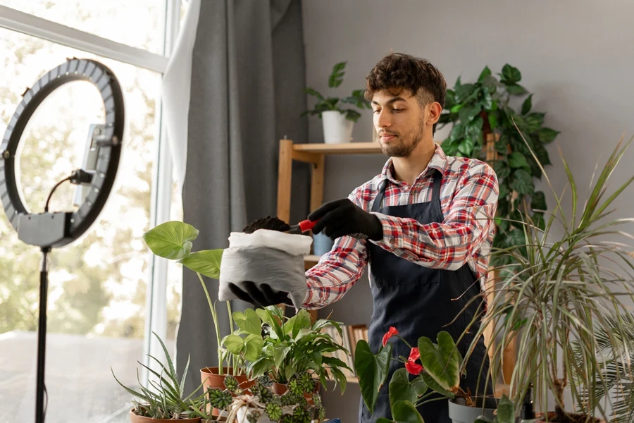 Man filming himself repotting a plant 