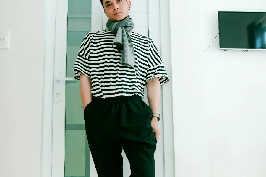 Man in Black and White Striped Shirt Leaning on Door