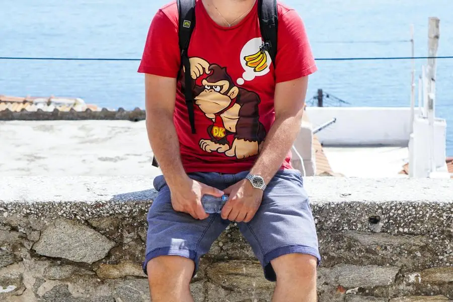 Man in Red T-shirt Sitting on a Concrete Platform by Ala J Graczyk