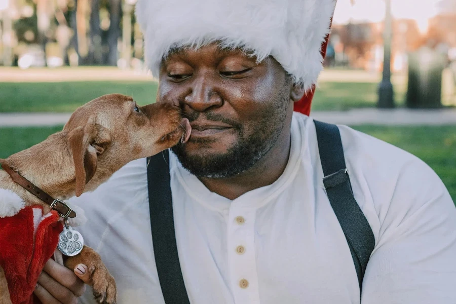 Man in Santa Hat Kissing His Dog