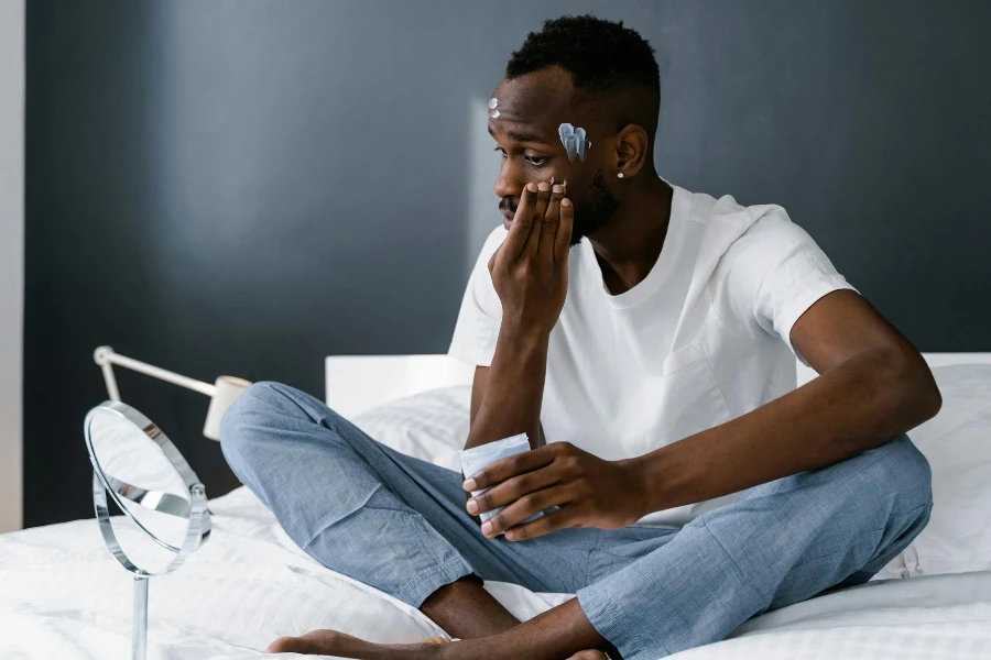 Man in White Crew Neck T-shirt Sitting on Bed