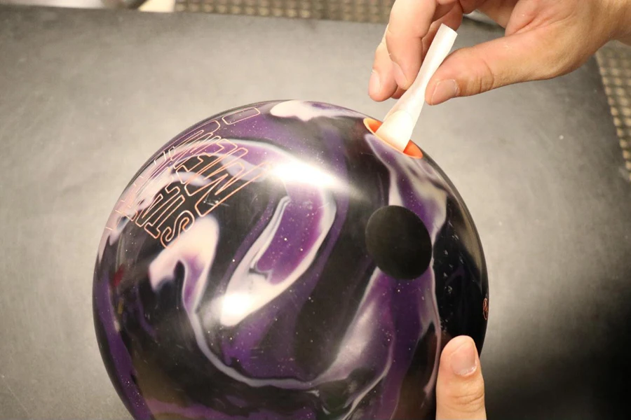 Man putting thumb tape in a bowling ball