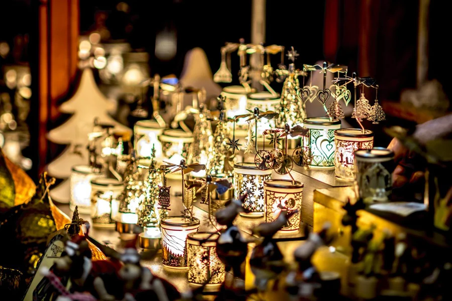 Many decorated Christmas lamps stand as decoration on a table against a blurred background