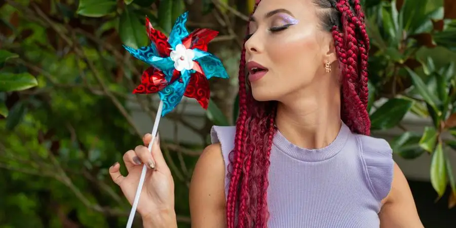 Model with Braided Hair in a Lavender Blouse Blowing on a Pinwheel by Angel Sanchez