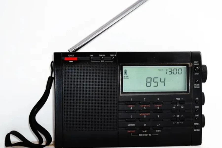 Modern black shortwave radio with antenna and digital display on a white background