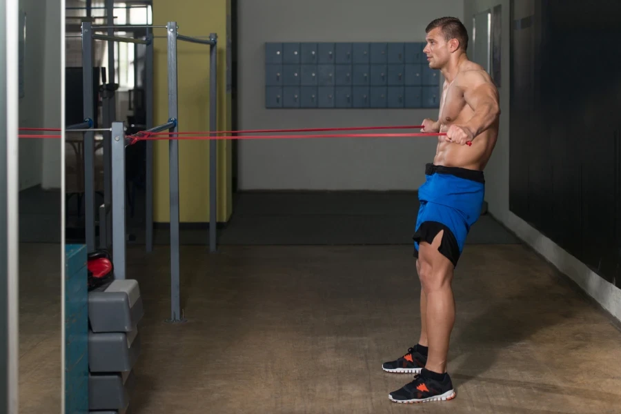 Muscular Man Training Stretching With Fitness Rubber Bands