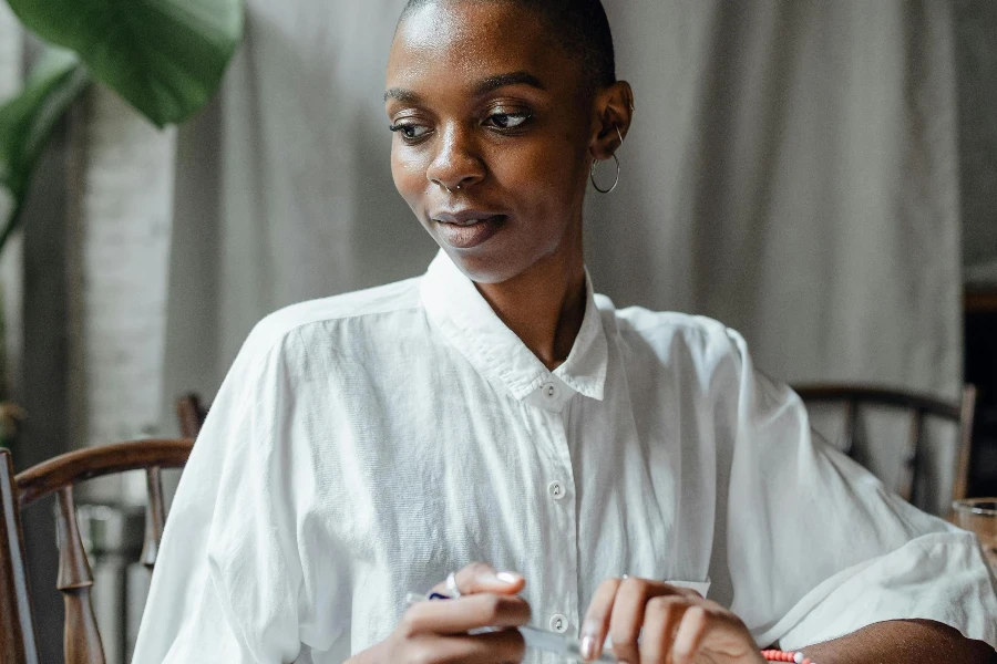 Pensive young bald African American female in white shirt