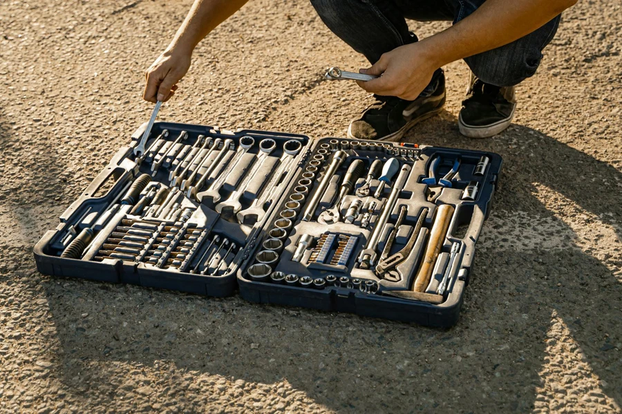 Person Crouching Near a Set of Hand Tools and Wrenches on Ground