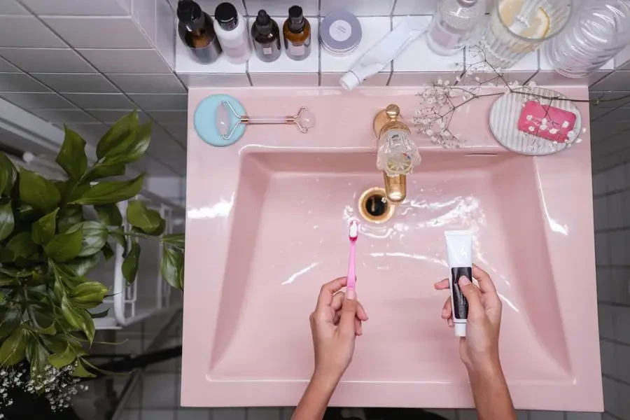 Person Holding Pink Toothbrush by Ron Lach