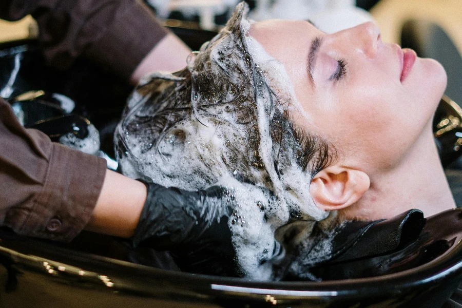 Person Washing Womans Hair by cottonbro studio