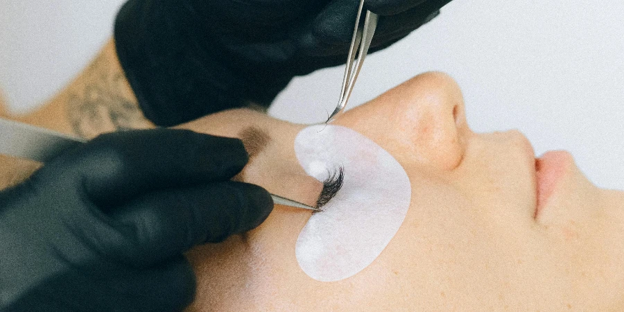 Person Working on Eyelash of a Woman