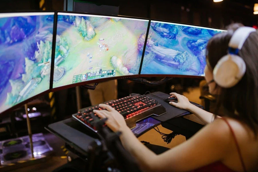 Person playing a PC game with three monitors