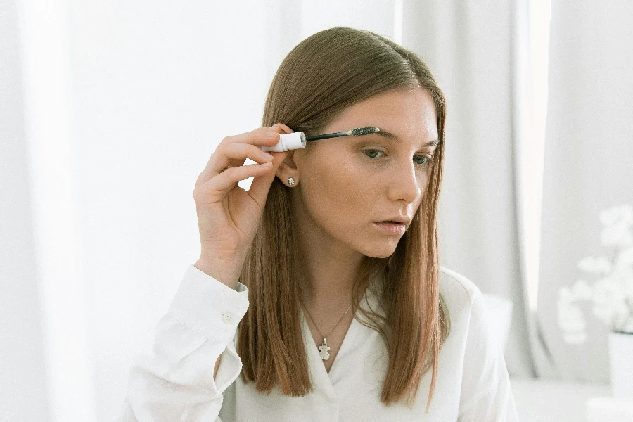 Photo Of Woman Applying Eyebrow Mascara by KATRIN BOLOVTSOVA