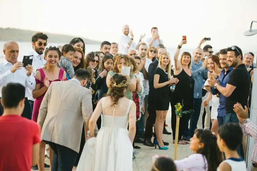 Photo of the Walking Groom and Bride and a Crowd of Wedding Guests by Taha Samet Arslan