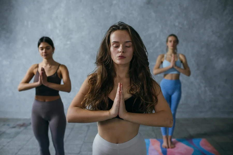 Photograph of Women Meditating with Their Eyes Closed 