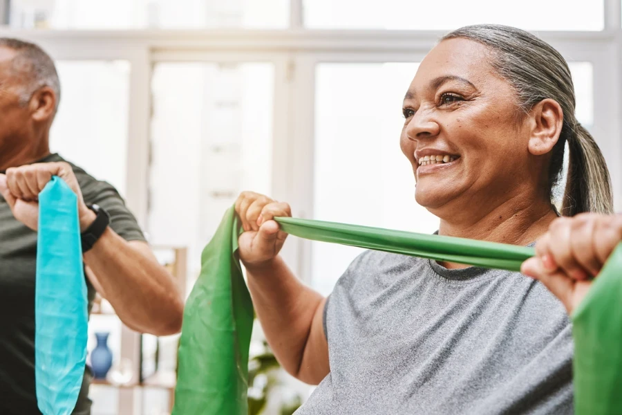 Physiotherapy, stretching band and senior couple with teamwork for muscle wellness, rehabilitation and support together