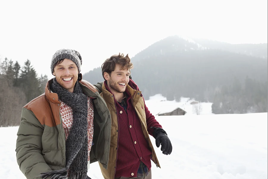 Portrait of happy men walking in snowy field