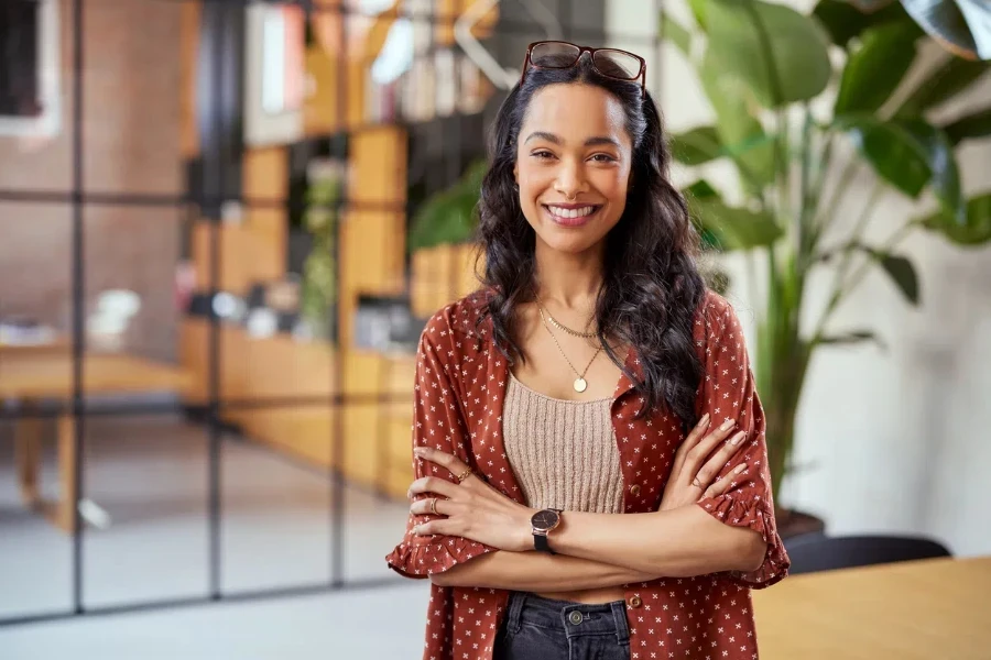 Portrait of smiling young multiethnic woman looking at camera with crossed arms