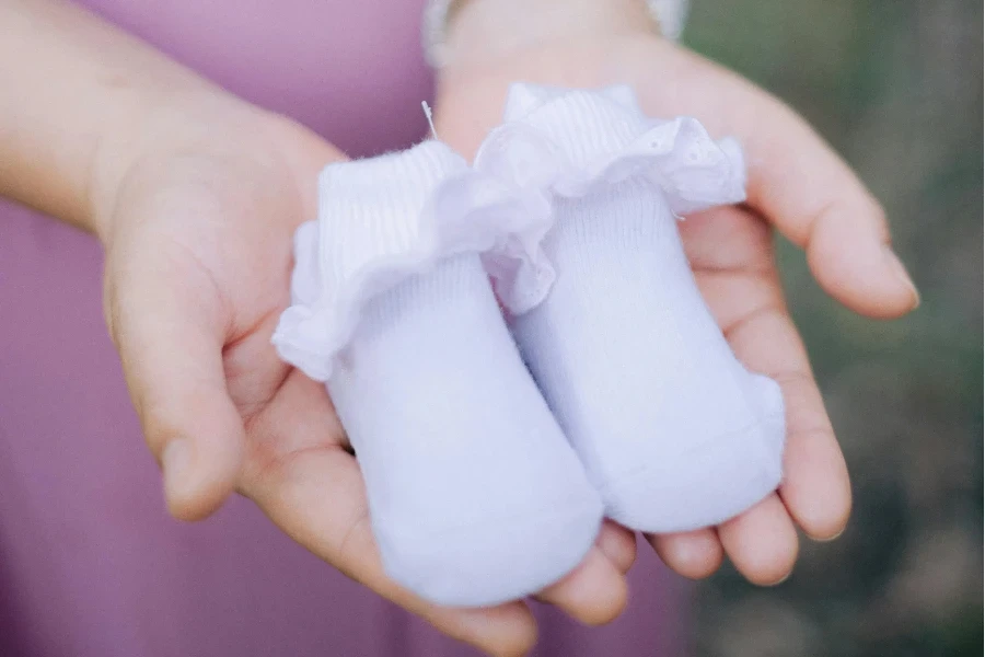 Pregnant Woman Holding Tiny Baby Shoes