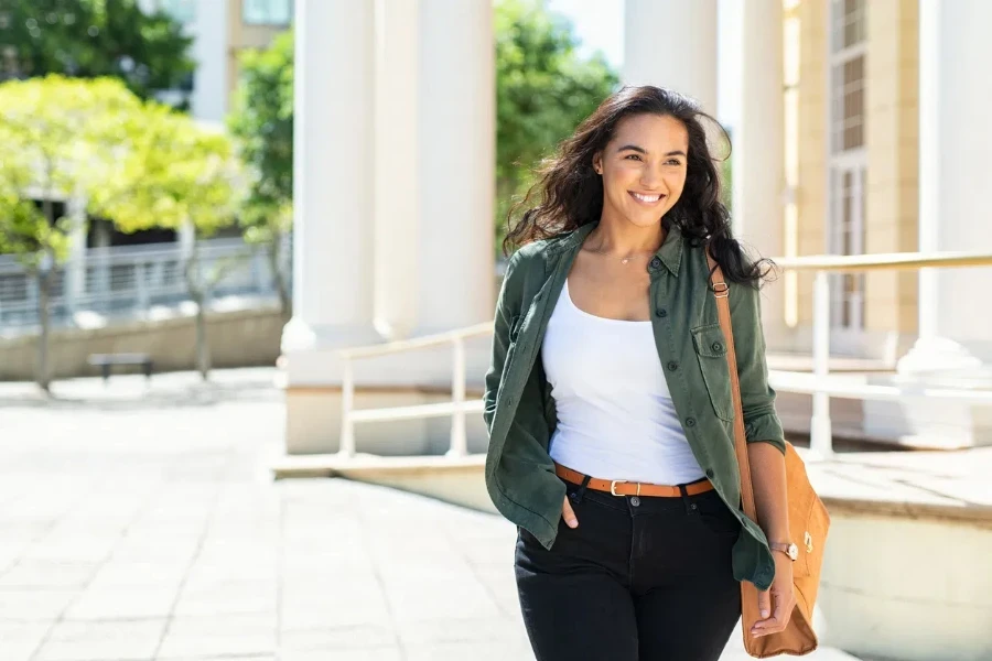 Pretty casual natural woman walking in urban street and looking away