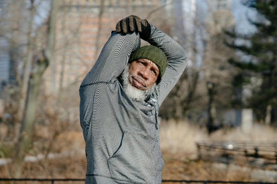 Senior black male doing exercise in park in fall