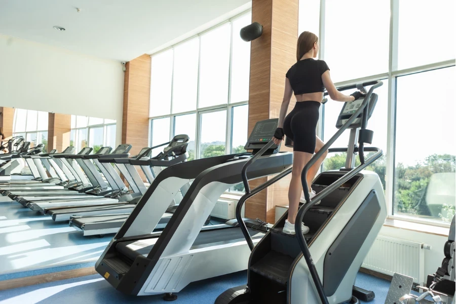 Sexy fit woman in sports clothes doing cardio exercise on steps exercise machine