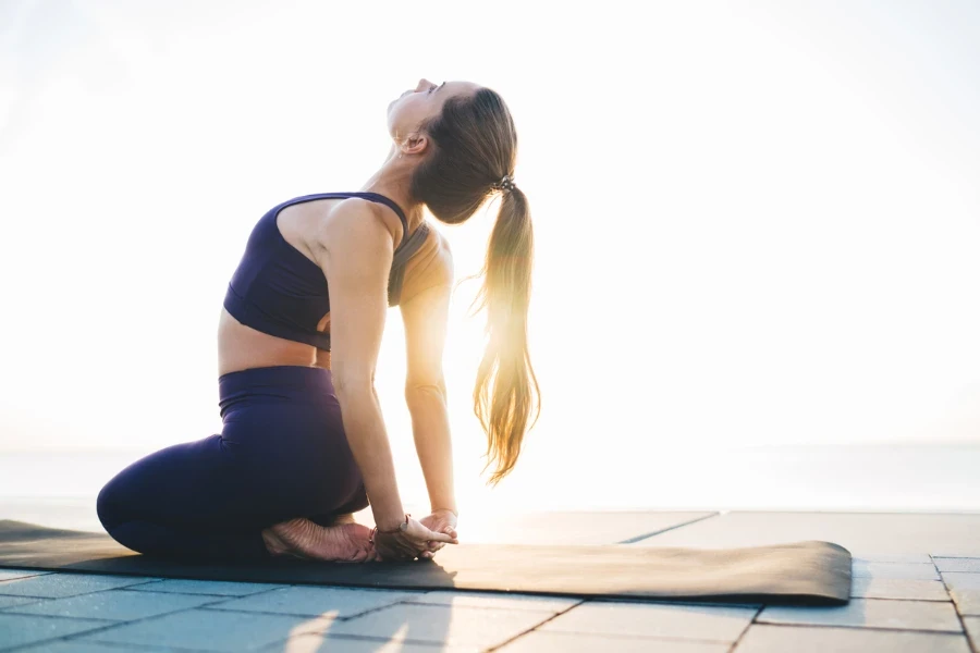 Side view of flexible barefoot lady performing Thunderbolt pose