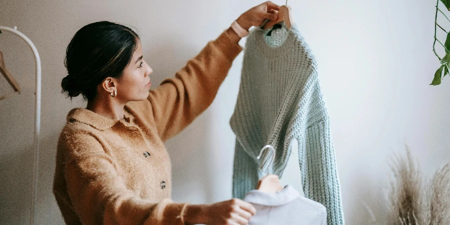 Vrouw in trendy vest kijkt naar gebreide trui