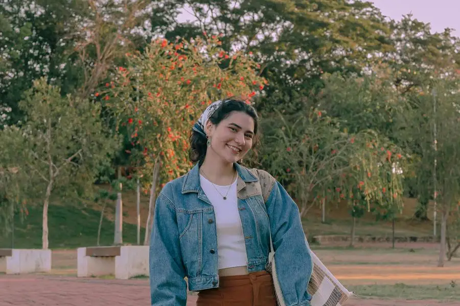 Smiling Woman in Brown Pants, Denim Jacket and Headscarf by Laura Oliveira