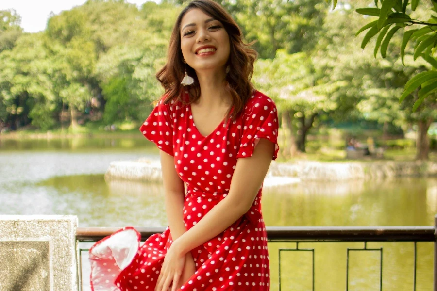 Lachende vrouw in rood-witte jurk met stippen