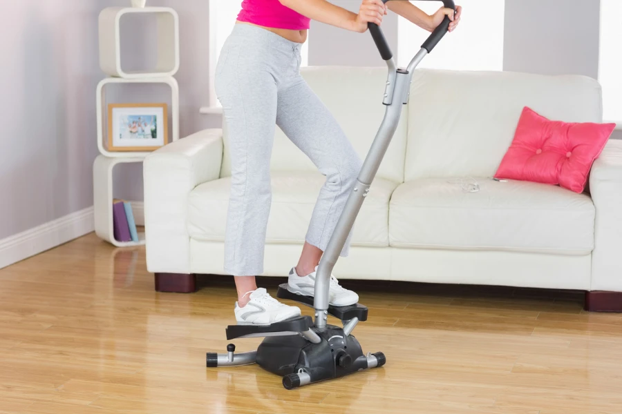Sporty woman training on step machine in bright living room