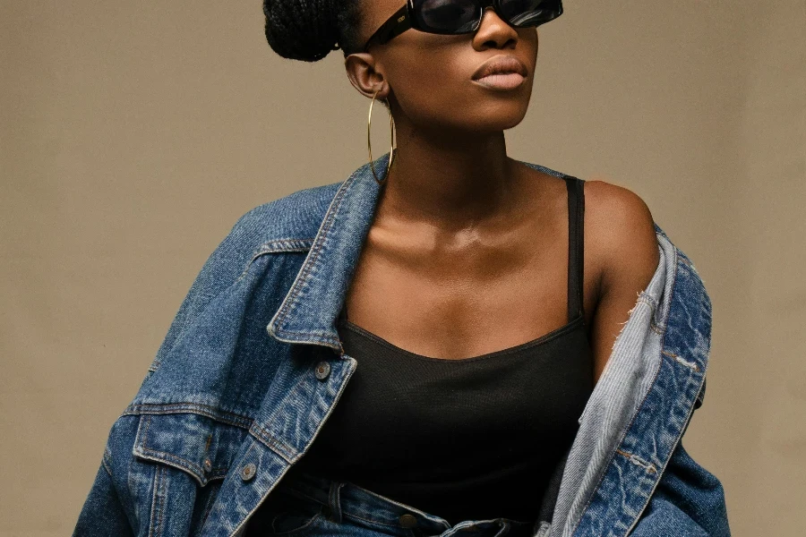 Stylish black woman in trendy outfit and sunglasses