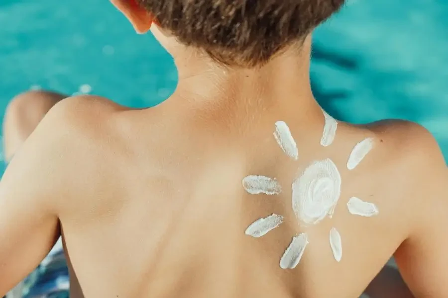 Sun Drawing Sunscreen on Child s Back Photo by Kindel Media