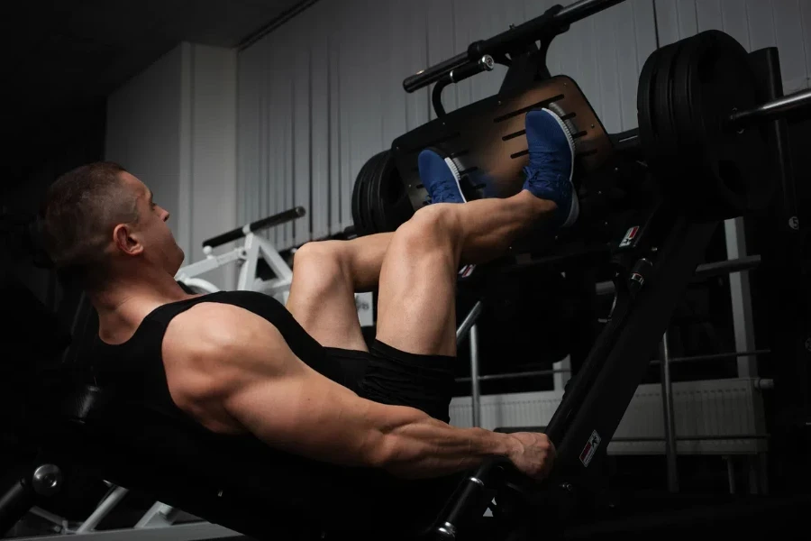 The athlete does an exercise on the simulator in the gym