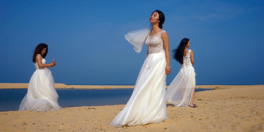 Three women in wedding dresses walking on the beach