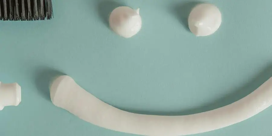 Toothbrush, a a Tube of Toothpaste and a Smile Painted with Toothpaste by hello aesthe