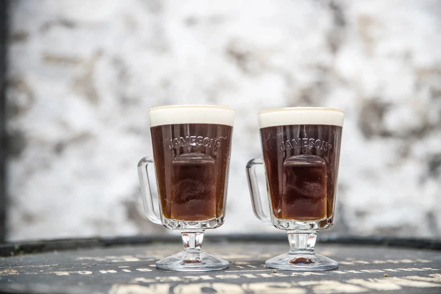Two Irish coffee glasses filled with beverages