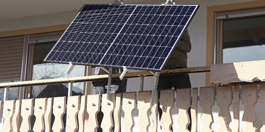 Two men assemble a balcony power plant to generate electricity