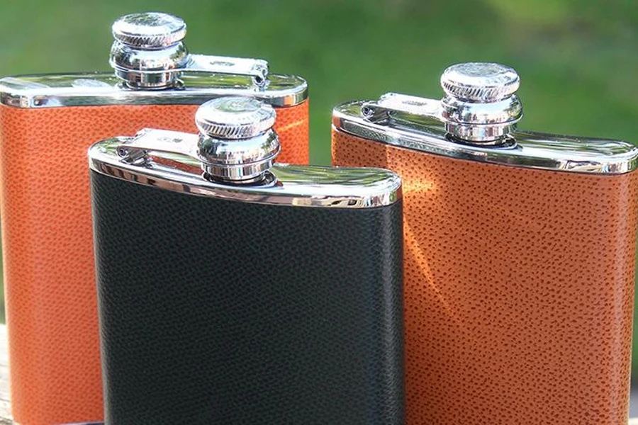 Two orange and a black hip flask