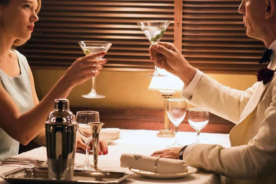 Two people enjoying a drink from a martini glass