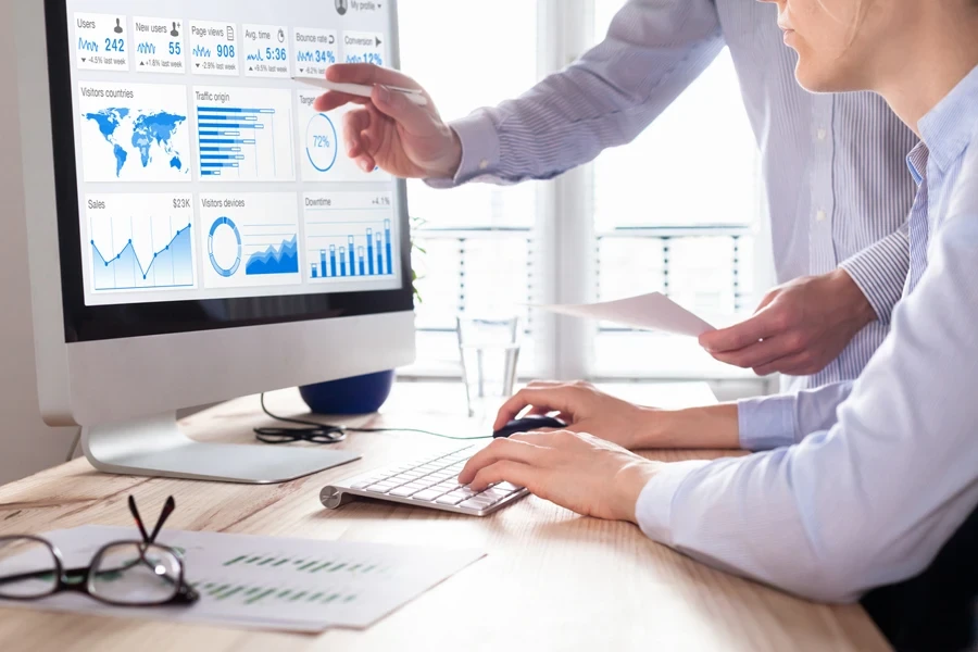 Two people looking at website analytics on a computer