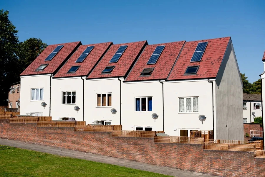 View of five new modern houses with Solar panels on the roofs against a clear blue sky